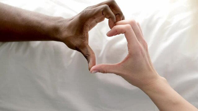 Heart from hands close up multiracial couple african man and caucasian woman lovers, Concept mixed family love on white.