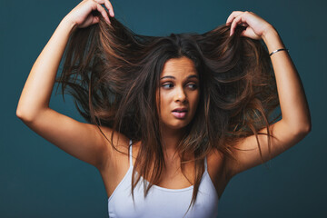 Good sense of humour, great sense of life. Studio shot of a beautiful young woman pulling on her...