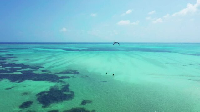 Blue lagoon with beginners doing kitesurfing lessons, in Paje beach on the island of Zanzibar, in Tanzania