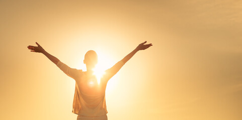 Feelings of hope light. Female lifting her arms up to the golden sky 