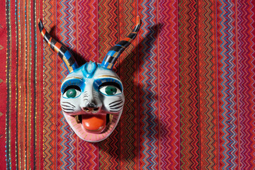 Typical devil Cusco´s mask on a traditional peru fabric