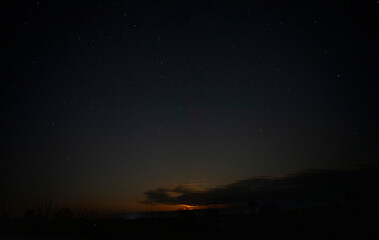 Fototapeta na wymiar Orange night sky with stars and clouds.