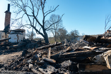 Various burnt things after the fire are scattered on the ground. A destroyed private house after...