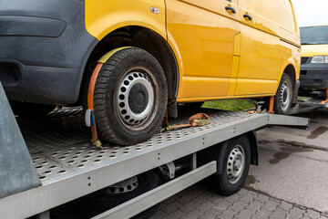 White small cargo truck car carrier loaded with two yellow van minibus on flatbed platform and semi trailer tow on roadside highway road. Volunteer support delivery transport for ukrainina people