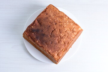 Homemade vanilla cake, displayed on plate and wooden background