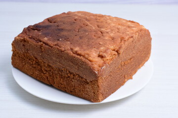 Fototapeta na wymiar Homemade vanilla cake, displayed on plate and wooden background