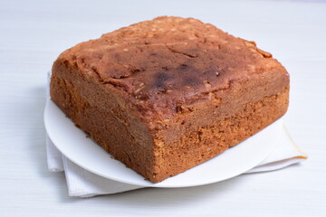 Homemade vanilla cake, displayed on plate and wooden background