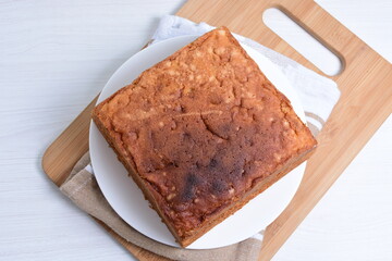 Homemade vanilla cake, displayed on plate and wooden background