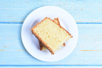 Homemade vanilla cake, displayed on a plate and portioned and on a wooden background