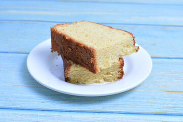 Homemade vanilla cake, displayed on a plate and portioned and on a wooden background