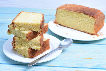 Homemade vanilla cake, displayed on a plate and portioned and on a wooden background
