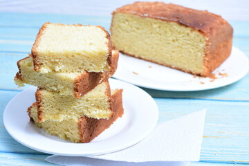 Homemade vanilla cake, displayed on a plate and portioned and on a wooden background