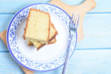 Homemade vanilla cake, displayed on a plate and portioned and on a wooden background
