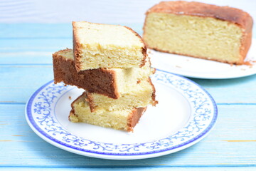 Homemade vanilla cake, displayed on a plate and portioned and on a wooden background