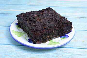 Traditional black ponque, with raisins, red wine flavor on wooden background