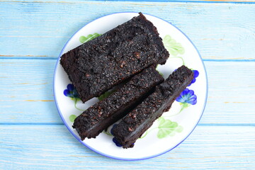 Traditional black ponque, with raisins, red wine flavor on wooden background