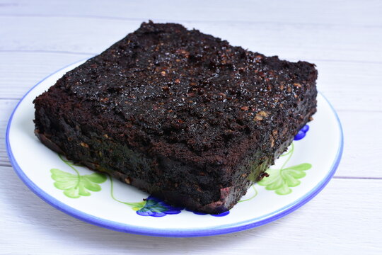 Traditional black ponque, with raisins, red wine flavor on wooden background