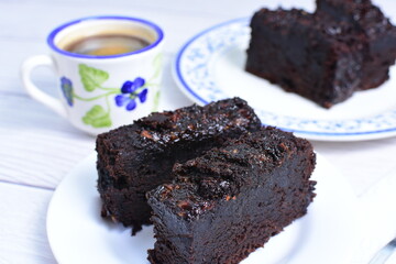 Traditional black ponque, with raisins, red wine flavor accompanied by a cup of coffee on a wooden...