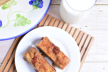 Fluffy bread cake with guava flavor accompanied by a glass of milk on a wooden background