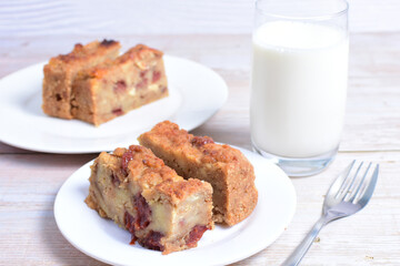 Fluffy bread cake with guava flavor accompanied by a glass of milk on a wooden background