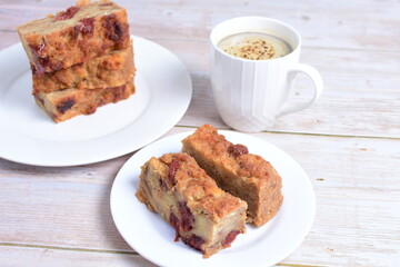 Fluffy bread cake with guava flavor accompanied by a cup of coffee on a wooden background