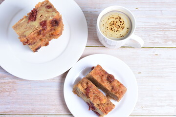 Fototapeta na wymiar Fluffy bread cake with guava flavor accompanied by a cup of coffee on a wooden background