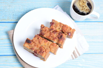 Fluffy bread cake with guava flavor accompanied by a cup of coffee on a wooden background