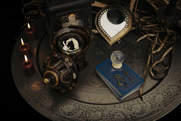 A fortune teller, witch stuff on a table, candles and fortune-telling objects. The concept of divination, astrology and esotericism.