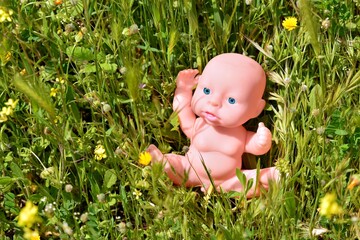 Muñeco bebé tradicional perdido entre la hierba