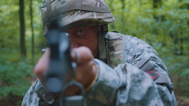 Portrait man soldiers holding machine gun forward to attack enemy in forest. Machine gun barrel look at camera.