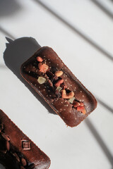 Homemade banana bread with walnut under morning sunlight from window on white background. Traditional American cuisine. Slice of loaf.