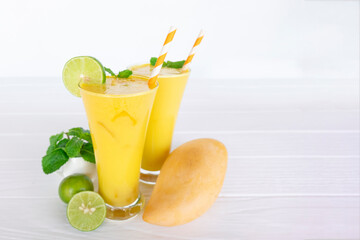 Mango smoothies yellow colorful fruit juice milkshake blend beverage healthy high protein the taste yummy In glass,drink to lose weight drink episode morning on white gray background.