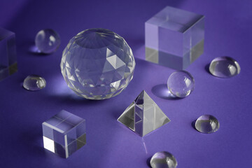 Crystal prism refracting light, magic crystals and pyramid, sphere and cube on purple background....