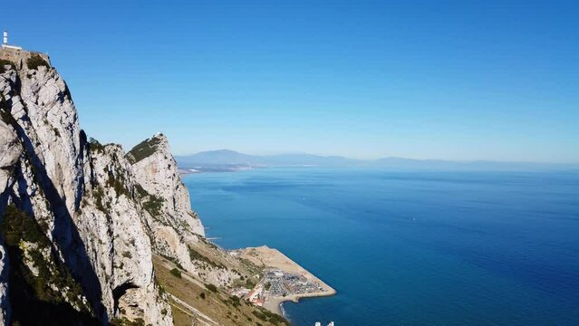 Gibraltar overview.  In sunshine. Pan left from the sea to reveal the Rock