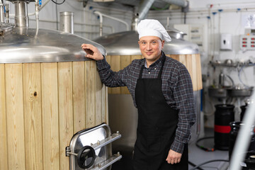 Portrait of confident professional brewmaster posing in brewery. Concept of vocation and successful...