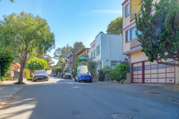 Street in the middle of residential area with parked vehicles in San Francisco, California