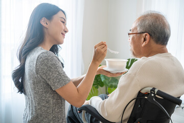 Asian beautiful young daughter support to elderly father on wheelchair