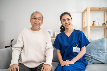 Portrait of Asian caregiver nurse sit on sofa and take care senior man