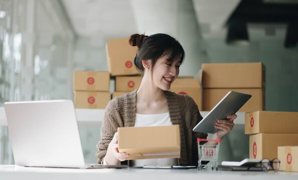 Startup small business entrepreneur SME, asian woman packing cloth in box. Portrait young Asian small business owner home office, online sell marketing delivery, SME e-commerce telemarketing concept