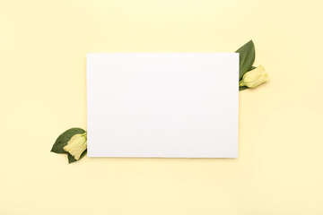 Blank sheet of paper and flowers on color background