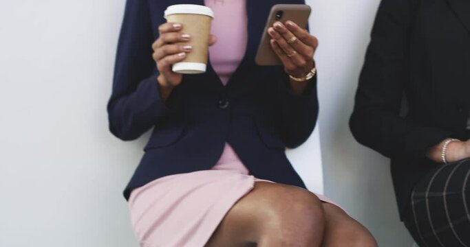 Armed with their device of choice for optimum productivity. 4k video footage of a group of businesspeople using digital devices while sitting in a line against a white background.