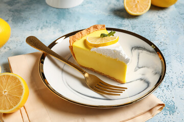 Plate with piece of tasty lemon pie on blue background