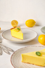 Plates with pieces of tasty lemon pie and fresh fruits on white background