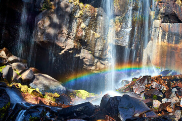 cascada con grandes rocas, agua cayendo y un arcoiris enfrente en mexiquillo durango