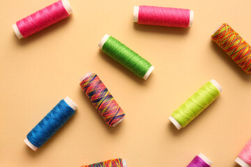 Multicolored thread spools on color background