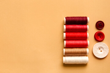 Multicolored thread spools and buttons on color background