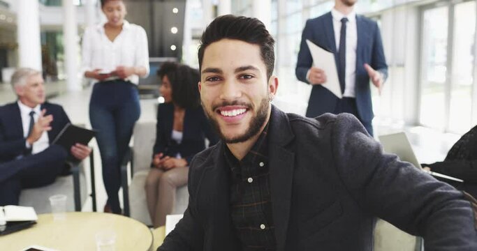 Im always ready for business. 4k video footage of a businessman looking at the camera while sitting with a group of businesspeople.