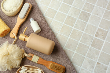 Set of bath supplies with clean towel on color tile