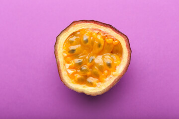 Delicious cut passion fruit on purple background