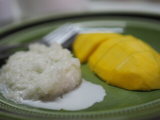 Mango sticky rice with coconut milk, sweet food dessert on green plate